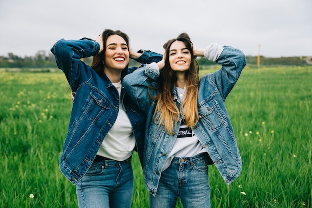 Amigas posando y sonriendo en el campo