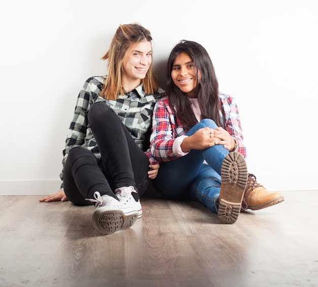 Amigas sentadas juntas en el suelo