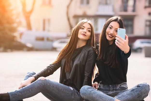 Amigas sentadas mientras se toman una foto