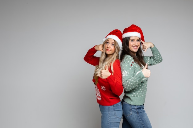 Las amigas con sombreros navideños rojos y blancos recomiendan algo