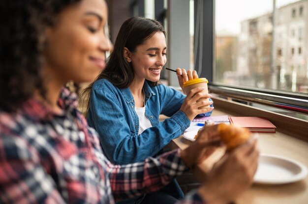 Amigas sonrientes almorzando juntos