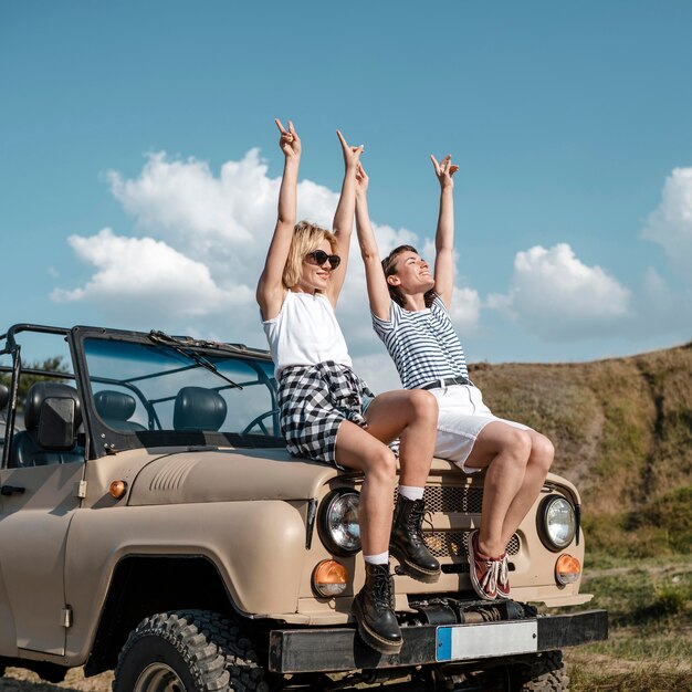 Amigas sonrientes divirtiéndose mientras viaja en coche