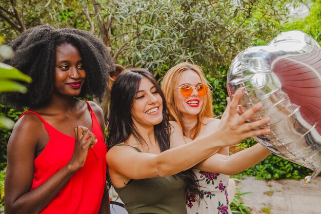 Amigas sonrientes con globo