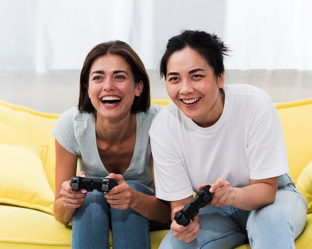 Amigas sonrientes jugando videojuegos juntos