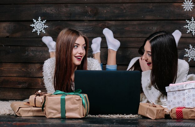 Amigas sonrientes tumbadas en el suelo mirándose