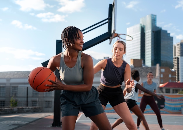 Foto gratuita amigas de tiro medio jugando baloncesto