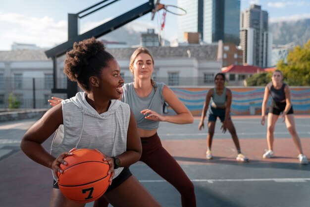 Amigas de tiro medio jugando baloncesto