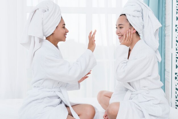 Amigas usando crema de belleza en un spa