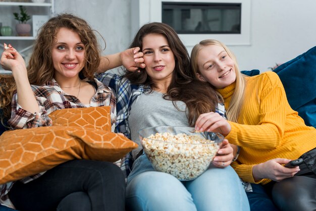 Amigas viendo una película mientras comen palomitas