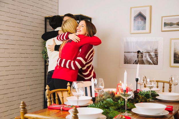 Amigos abrazándose antes de cena de navidad