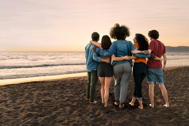 Amigos abrazándose a la orilla del mar