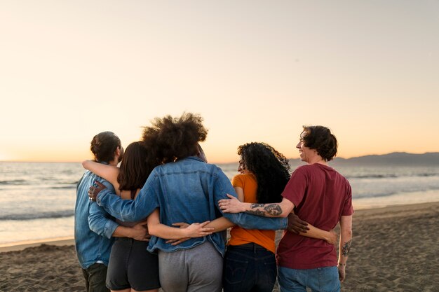 Amigos abrazándose a la orilla del mar