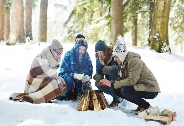Amigos acampando en el bosque de invierno