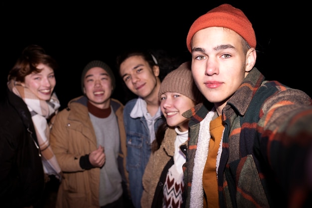 Amigos de adolescente de tiro medio en la noche