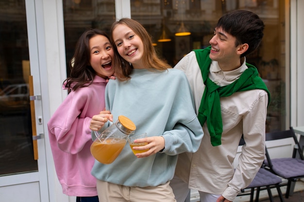 Amigos adultos bebiendo té de kombucha al aire libre