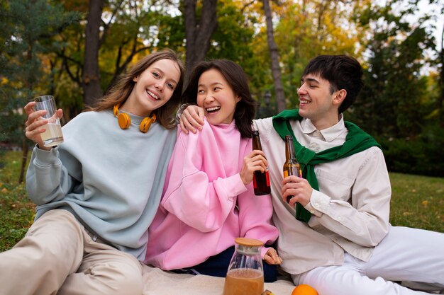 Amigos adultos bebiendo té de kombucha al aire libre