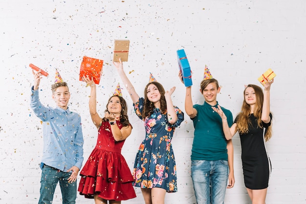 Foto gratuita amigos alegres adolescentes se ducharon con confeti arrojando en la fiesta de cumpleaños