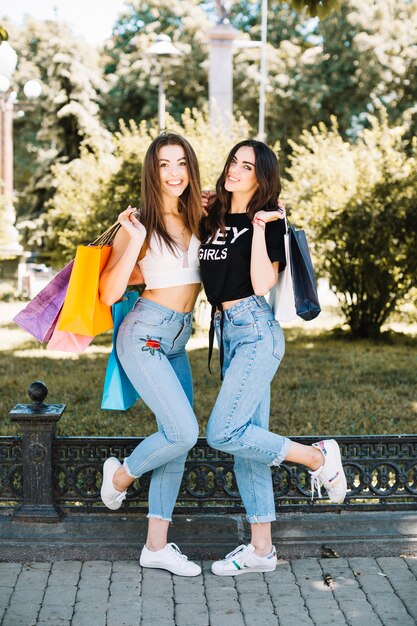 Amigos alegres con bolsas de papel