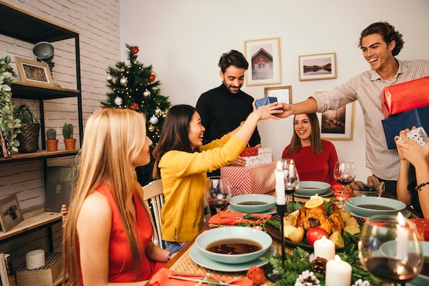 Foto gratuita amigos alegres en cena de navidad