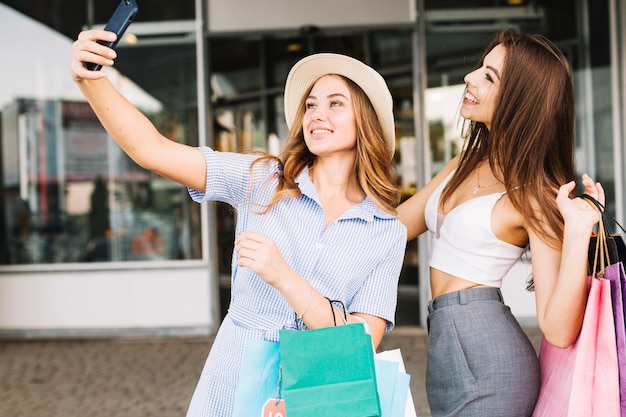 Amigos alegres tomando selfie en centro comercial