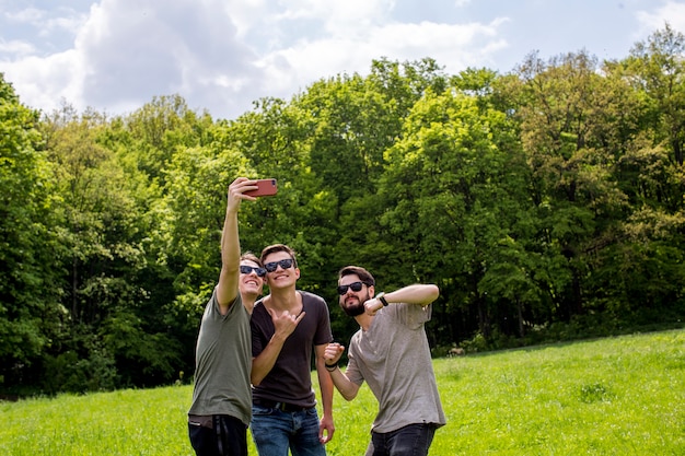 Amigos alegres tomando selfie en glade