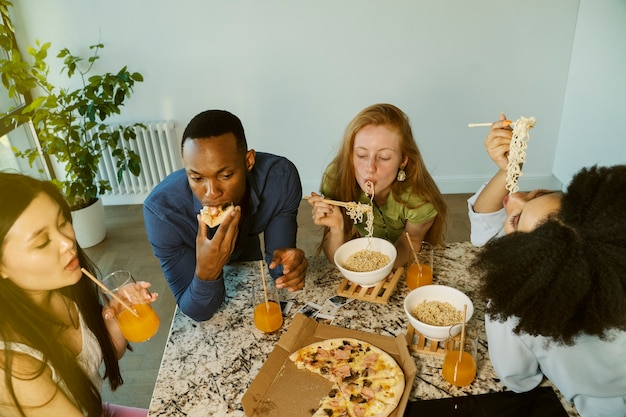 Amigos de alto ángulo comiendo juntos