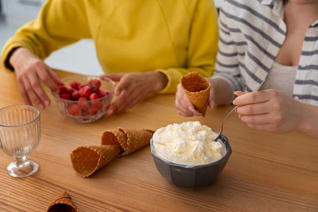 Amigos de alto ángulo comiendo sabroso helado