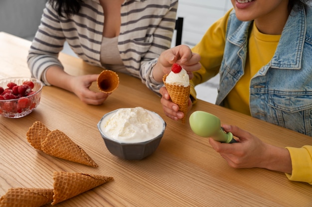 Amigos de alto ángulo comiendo sabroso helado