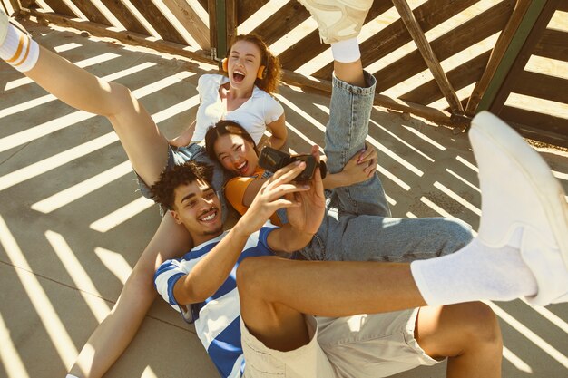 Amigos de alto ángulo tomando selfie con teléfono antiguo