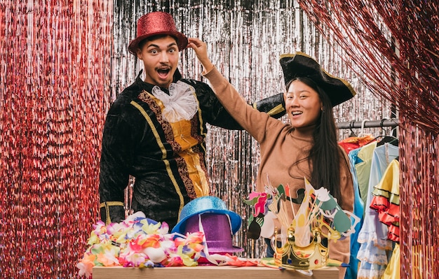 Amigos de bajo ángulo probando disfraces para la fiesta de carnaval