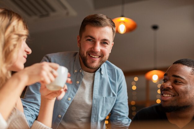 Amigos de ángulo bajo en el restaurante juntos