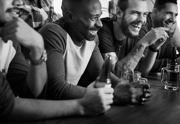 Amigos animando deporte en el bar juntos