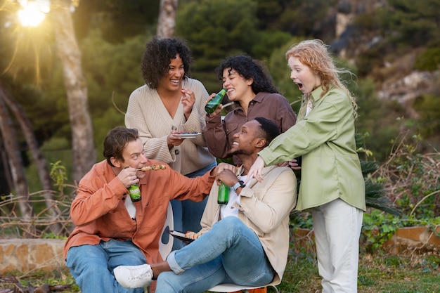 Amigos bebiendo cerveza y hablando durante la fiesta al aire libre