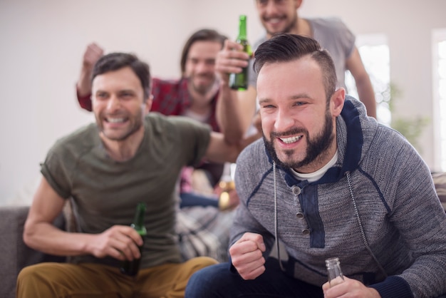 Amigos bebiendo cerveza y viendo el partido de fútbol