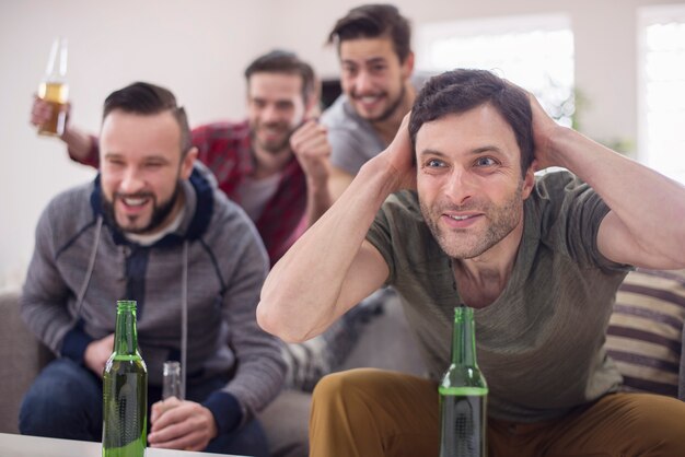 Amigos bebiendo cerveza y viendo el partido de fútbol