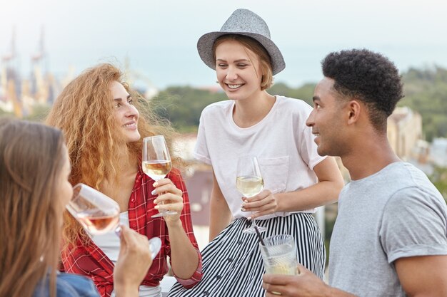 amigos bebiendo vino y cócteles juntos