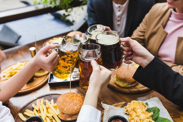 Amigos brindando con cerveza en restaurante