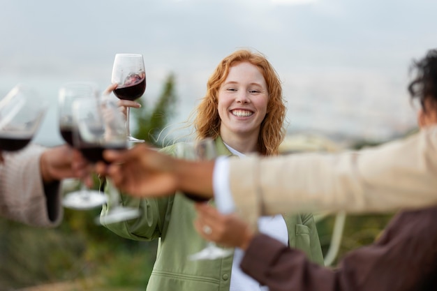 Foto gratuita amigos brindando con copas de vino durante la fiesta al aire libre