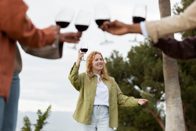 Amigos brindando con copas de vino durante la fiesta al aire libre