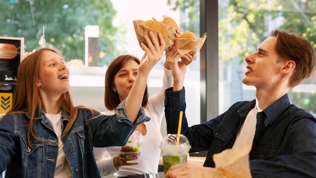 Amigos brindando con hamburguesas