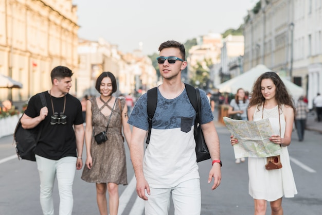 Foto gratuita amigos caminando en la calle con el mapa