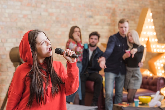 Amigos cantando al karaoke en una fiesta