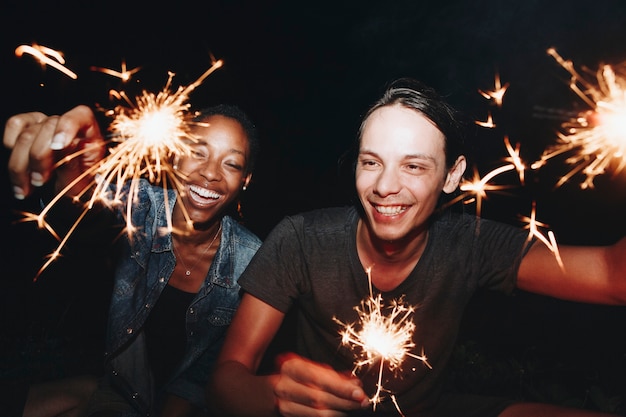 Amigos celebrando con bengalas en la noche