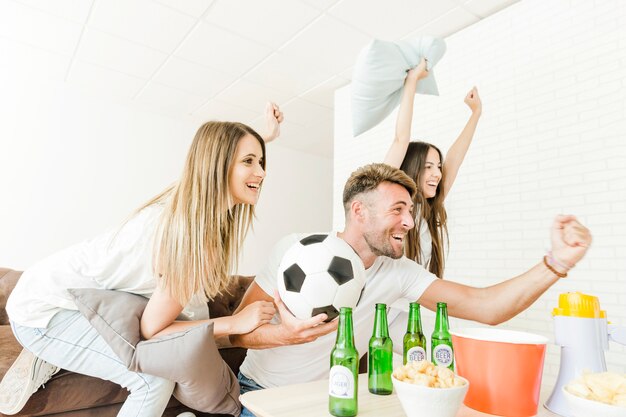 Amigos celebrando viendo fútbol en casa