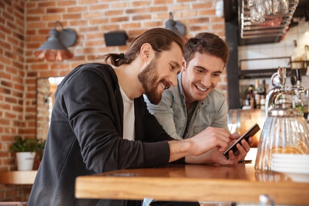 Amigos cerca del bar mirando el teléfono