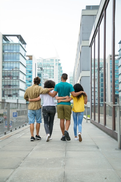 Amigos cercanos caminando juntos por la ciudad