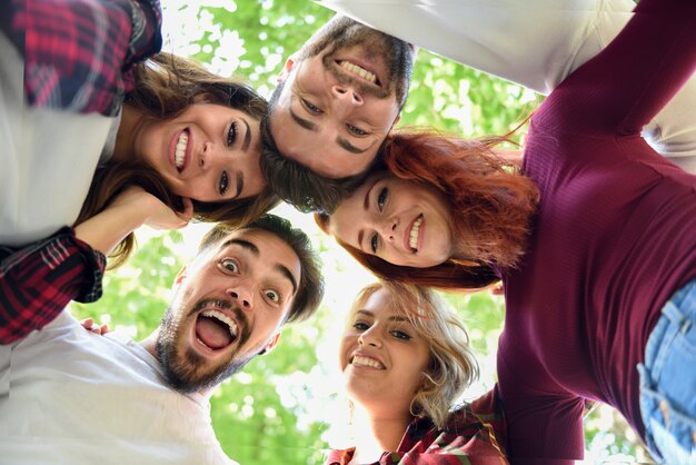 Amigos en círculo con las cabezas juntas sonriendo