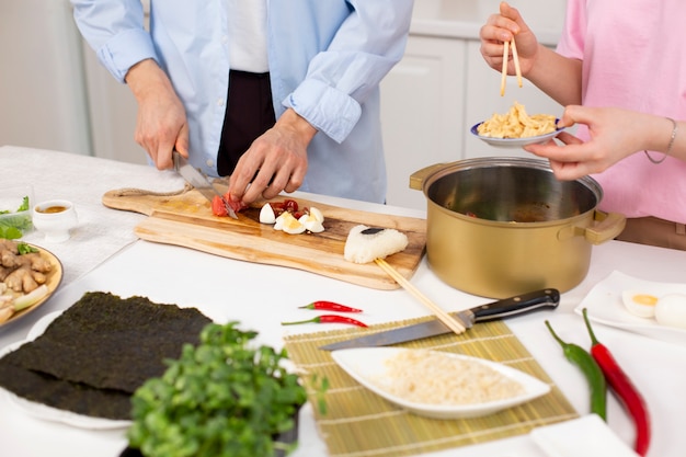 Amigos cocinando comida japonesa juntos