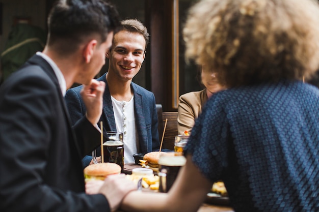 Foto gratuita amigos comiendo y conversando en restaurante