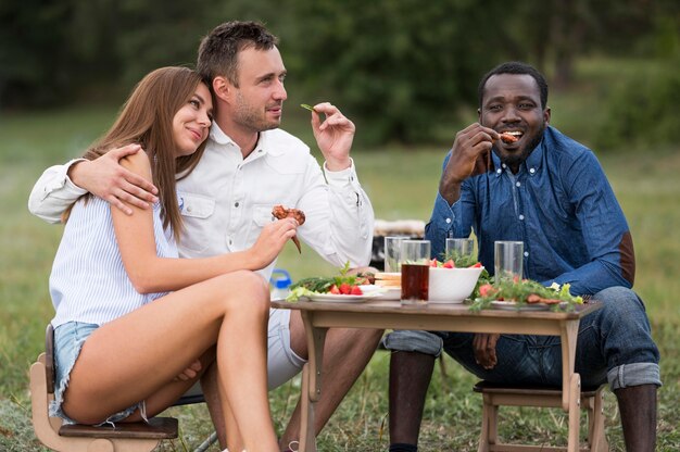 Amigos comiendo junto a la barbacoa